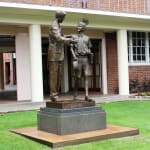 A closer look at the Shore Boys statue from a front angle, emphasizing the intricate details of the clothing and the expressions that capture the essence of mentorship and camaraderie.