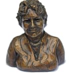 A bronze mini-bust of the mother, portraying her with a warm expression. The detailed sculpture captures her personality, with textured hair and a necklace accentuating her figure.