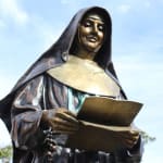 Bronze statue of St. Mary MacKillop holding a book and rosary, with a serene expression. The fine detailing of her robes and facial features conveys her dedication and compassion as Australia's first saint.