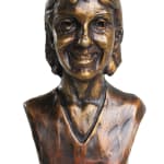 A bronze miniature bust of Lisa Mari, showcasing her smiling face with detailed features. The sculpture reflects a warm and loving expression, capturing her likeness in a heartfelt and artistic manner.