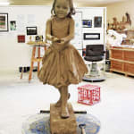 Clay model of a young girl holding a flower in her outstretched hands in a gesture of offering, created as part of the Expressions of Love series at Hunter Valley Gardens.