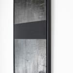 Side angle view of Mathilde Lefort’s 'Mirror', showcasing the texture and depth of the painting. The artwork's frame is thick, emphasizing its object-like quality and the stark contrast between the dark surfaces and the light wall behind, inviting contemplation on the nature of perception and materiality