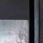 Close-up view of the 'Mirror' artwork, focusing on the textural contrast between the rough, mottled cement upper half and the smoother, darker iron-infused lower half. This division creates a visual tension and plays on the concept of negative depth, engaging the viewer in a meditative observation of form and emptiness.