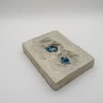 A sculpture by Shabez Jamal consisting of a photograph suspended in poured concrete that remains partially visible.