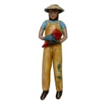 Slate Gray Gallery Artist Julie McNair's clay and oil sculpture of a gardener wearing yellow overalls with a vine on the left leg holding a red pepper titled "pick a pepper"