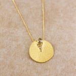 Yellow gold disk pendant with brown and white diamonds by Fringe Gallery studio jeweler Barbara Heinrich