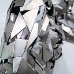 Stainless steel sculpture of a person laying on their side with their arm under their head by slate gray gallery artist David Davis