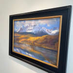 Pastel painting in a black frame of a mountain range with a body of water in front of it by Slate Gray Gallery artist Bruce A. Gomez