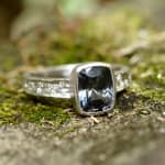 Grey spinel stone in platinum band with diamonds by studio jeweler Barbara Heinrich (front view in the grass)