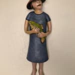 Ceramic sculpture of a woman holding a fish by Slate Gray Gallery artist Julie McNair