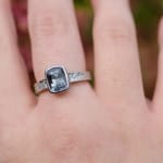 Grey spinel stone in platinum band with diamonds by studio jeweler Barbara Heinrich (front view on a finger)