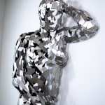 Stainless steel sculpture of a person laying on their side with their arm under their head by slate gray gallery artist David Davis