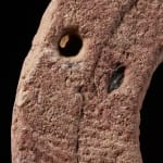 Ancient Red Stone Village Millstone on a wooden stand , most probably from Ghana.,
