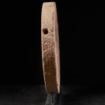 Ancient Red Stone Village Millstone on a wooden stand , most probably from Ghana.,