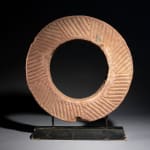 Ancient Red Stone Village Millstone on a wooden stand , most probably from Ghana.,