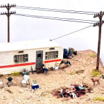 man sitting outside trailer with multiple dead bodies in front of him