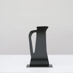 Metal sculpture of a black jug with a handle