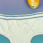 Painting of a green cabbage, a carrot and a purple cabbage above a white pair of underwear briefs.