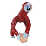 Ceramic sculpture of a monkey with red spots, a blue face, hands and feet, holding a large onion.