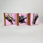 Three small paintings of dragon heads on pink backgrounds