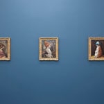 Install photo of Alison Friend's paintings hanging on a blue wall