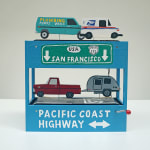 Diorama-like sculpture with a small wind up crank featuring a red truck towing a small silver trailer, a teal plumbing van, and mail truck with details of CA highway signs relating to San Francisco by We Are Out of Office