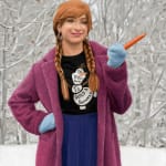 Painting of princess Anna standing in a snowy forest holding a carrot