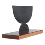 Scott Albrecht steel sculpture - two semi circles, larger one balanced on smaller one. Wood base - side view