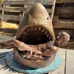 sculpture of a shark with a man in his mouth