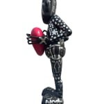 left side view of a black and silver robot statue holding a heart
