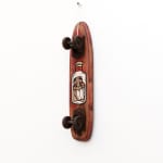 Brown wooden vintage skateboard with GATS character in a glass jar painted on the bottom of it