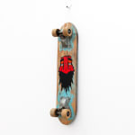 Vintage wooden skateboard with GATS character with a red face and big black beard painted on the bottom of it