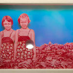 two young girls painted in pink standing in a bush