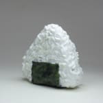 Stephen Morris "Rice Ball" ceramic sculpture of realistic rice ball wrapped in seaweed featuring eyes mouth and nose