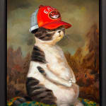 cat sitting upright with an orange hat