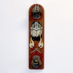 A vintage wood skateboard with a painted image of a masculine face and to lit matches forming an "X".