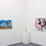 corner of a room with white walls with a gold statue on a padastal in the middle and larger paintings on each side