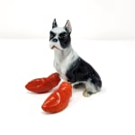 Debra Broz - ceramic and mixed media sculpture, black and white bulldog with red lobster claw replacing the front legs, dog in sitting position