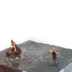 sculpture of a woman on a rock and another woman being eaten by a shark in the water