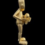 right side view of a gold robot statue holding a heart