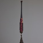 suspended mixed media bat sculpture with a bronze bell hanging at the end by Lucien Shapiro