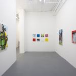 wide angle image of a gallery room with white walls with one painting on the left wall, two piantings on the right wall, and a grid of smaller paintings in the middle