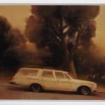 Kim Cogan - Painting of a white car driving down a hill, on the side of the road was trees, the tone of the painting is yellowish and grey