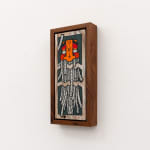 GATS character with long white tentacles and an orange and red face on a wood background