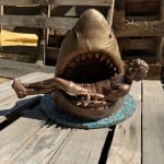 sculpture of a shark with a man in his mouth