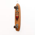 Brown wooden vintage skateboard with a light brown and red beard GATS character painted on the bottom of the board