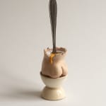 sculpture of a spoon inside of a cup shaped like a butt