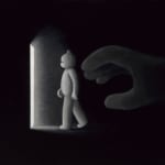 black room with a white bear walking towards a door with light shining from it