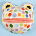 Lorien Stern - ceramic sculpture of a frog head with colorful polka dots.