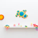 Installation shot of sculpture with multiple circular objects with a rainbow gradient by Dan Lam